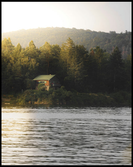 Leinwandbild von einem Haus am See das zwischen einigen Bäumen hervorschaut.