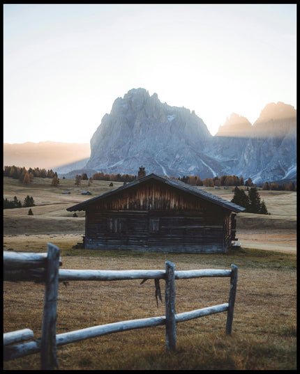 Ein Poster von einer rustikalen Hütte in einer herbstlichen Berglandschaft.