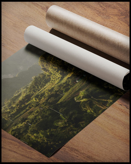 Ein Poster von einer grünen, tropischen Landschaft in Kuba mit Bergen im Hintergrund, gerollt auf einer Holzoberfläche liegend