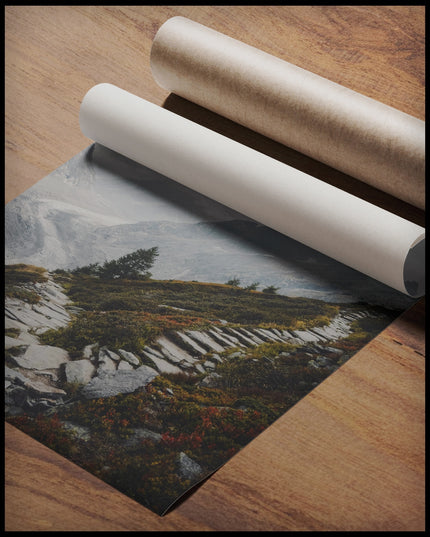 Ein Poster von einem Wanderweg aus steinernen Treppen inmitten einer Berglandschaft, gerollt auf einer Holzoberfläche liegend