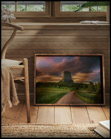 Ein gerahmtes Poster vom Devils Tower bei Sonnenuntergang, vor einem Fenster an die Wand angelehnt