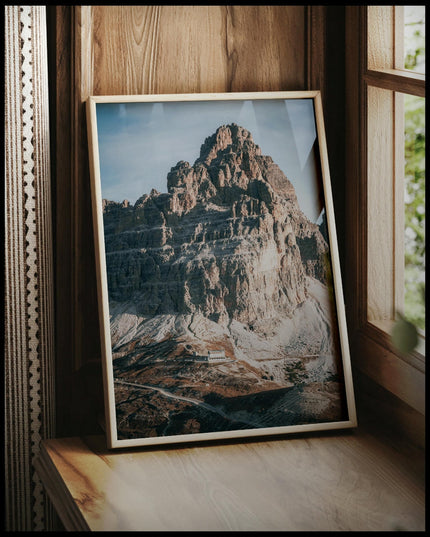 Ein gerahmtes Poster von einem massiven Berg in den Dolomiten, vor einem Fenster an die Wand angelehnt