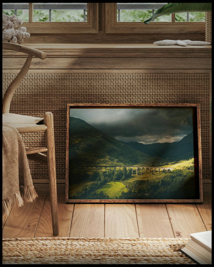 Ein gerahmtes Poster von dem Glenfinnan-Viadukt bei bewölktem Himmel, vor einem Fenster an die Wand angelehnt