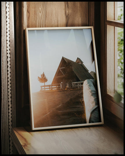 Ein gerahmtes Poster von einer Kapelle in den Dolomiten, vor einem Fenster an die Wand angelehnt